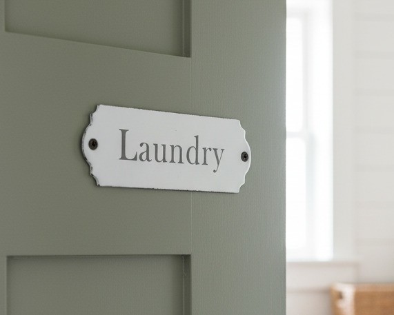 Our laundry sign mounted on a laundry room door. The text reads laundry. There are two fixing holes for easy installation.